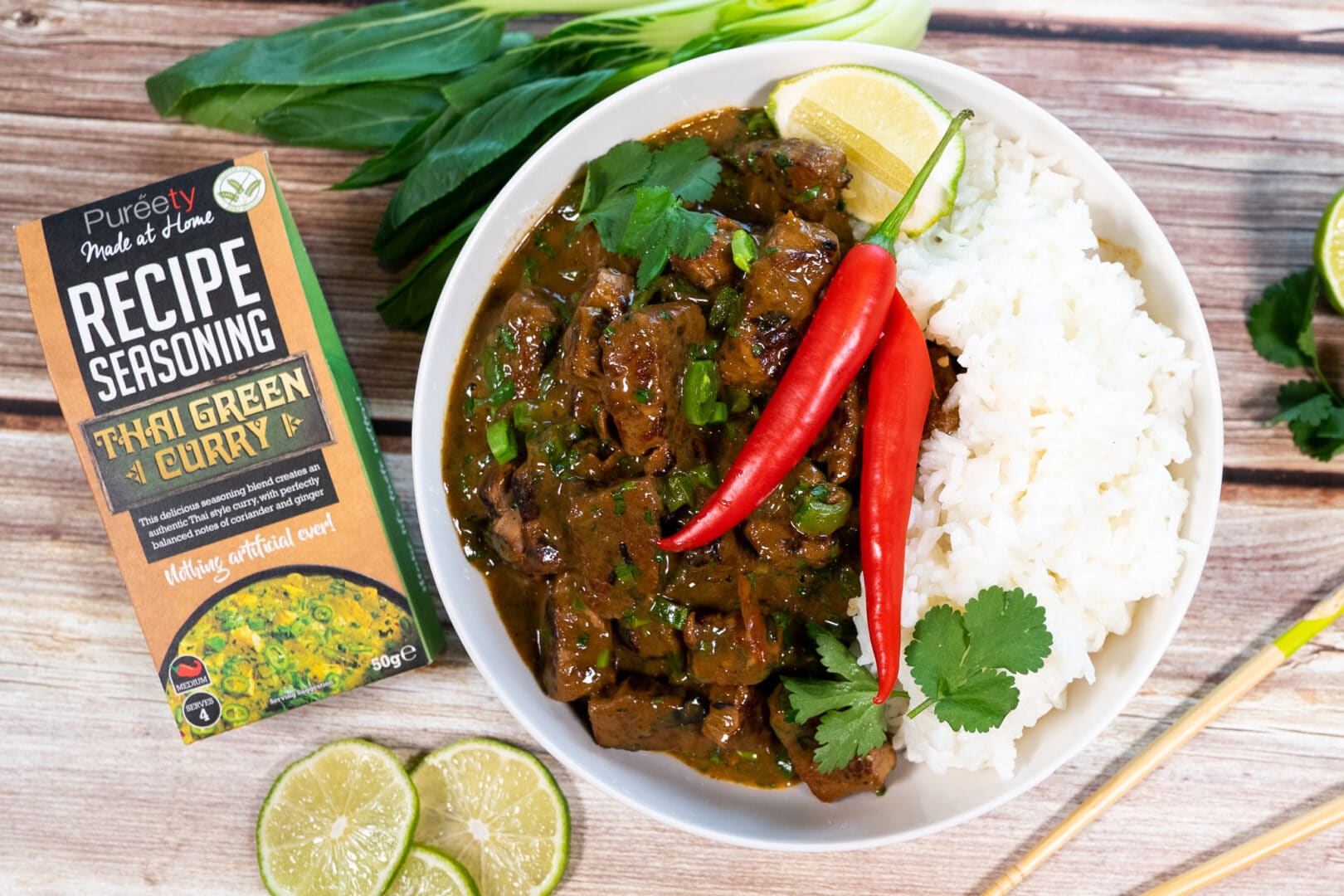 Top down image of hot and sour beef curry garnished next to the product pack
