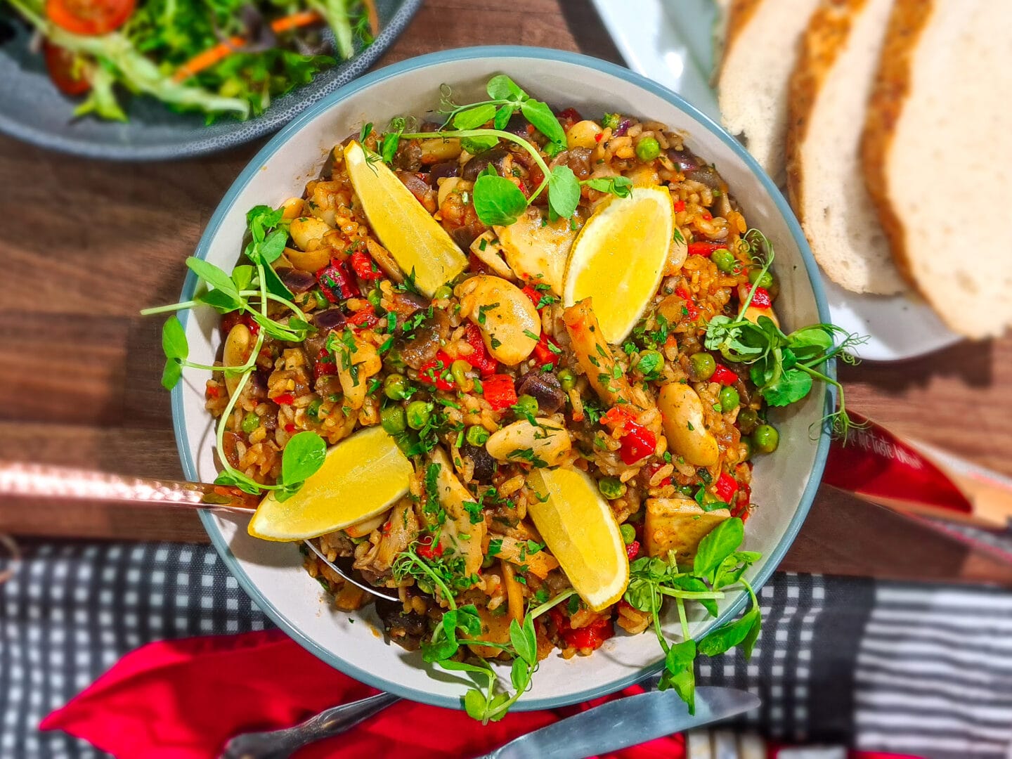 Mushroom, Pepper and Butterbean Paella in a bowl with a side of bread