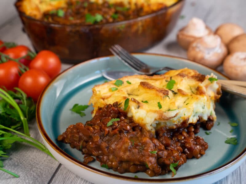 Plated cottage pie surrounded by vegetables